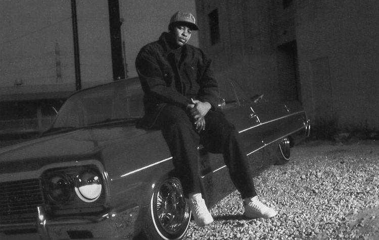 Iconic photo of Dr. Dre sitting on his classic low-rider convertible.